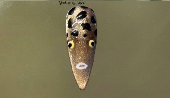 Gold chrome stiletto nail with leopard spots and an eye